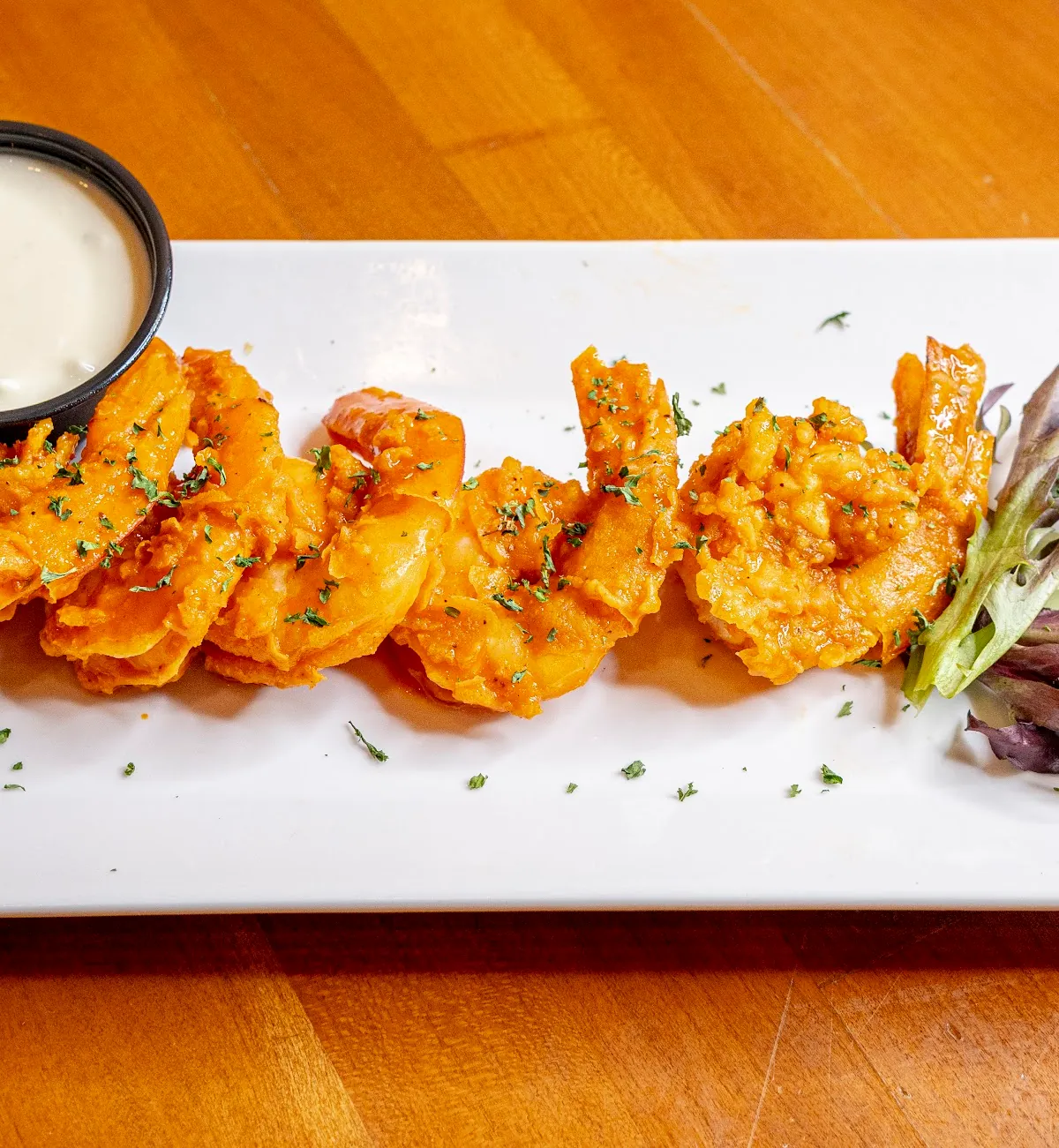 BBQ shrimp lined up on a long plate