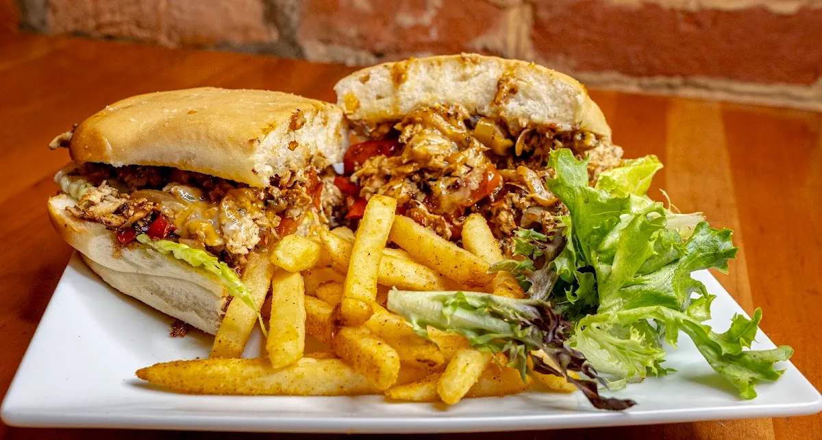 Jerk chicken cheesesteak on coco bread with fries