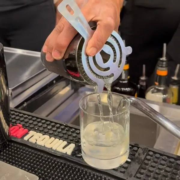 Bartender straining a cocktail